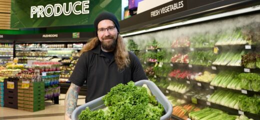 Sobeys employee holding a bin of lettuce in front of a wet wall