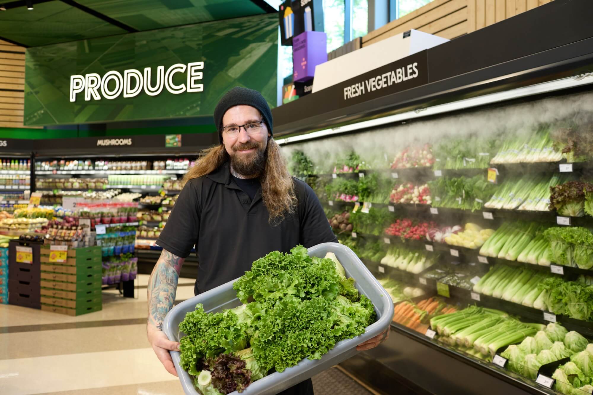 Sobeys employee holding a bin of lettuce in front of a wet wall