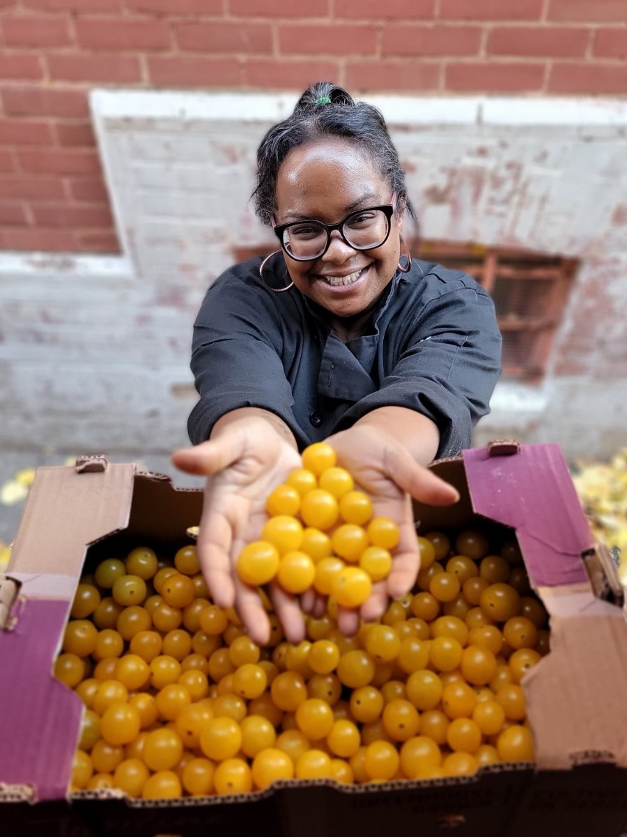 Employé de Second Harvest devant ses camions de livraison avec des groseilles à maquereau en mains