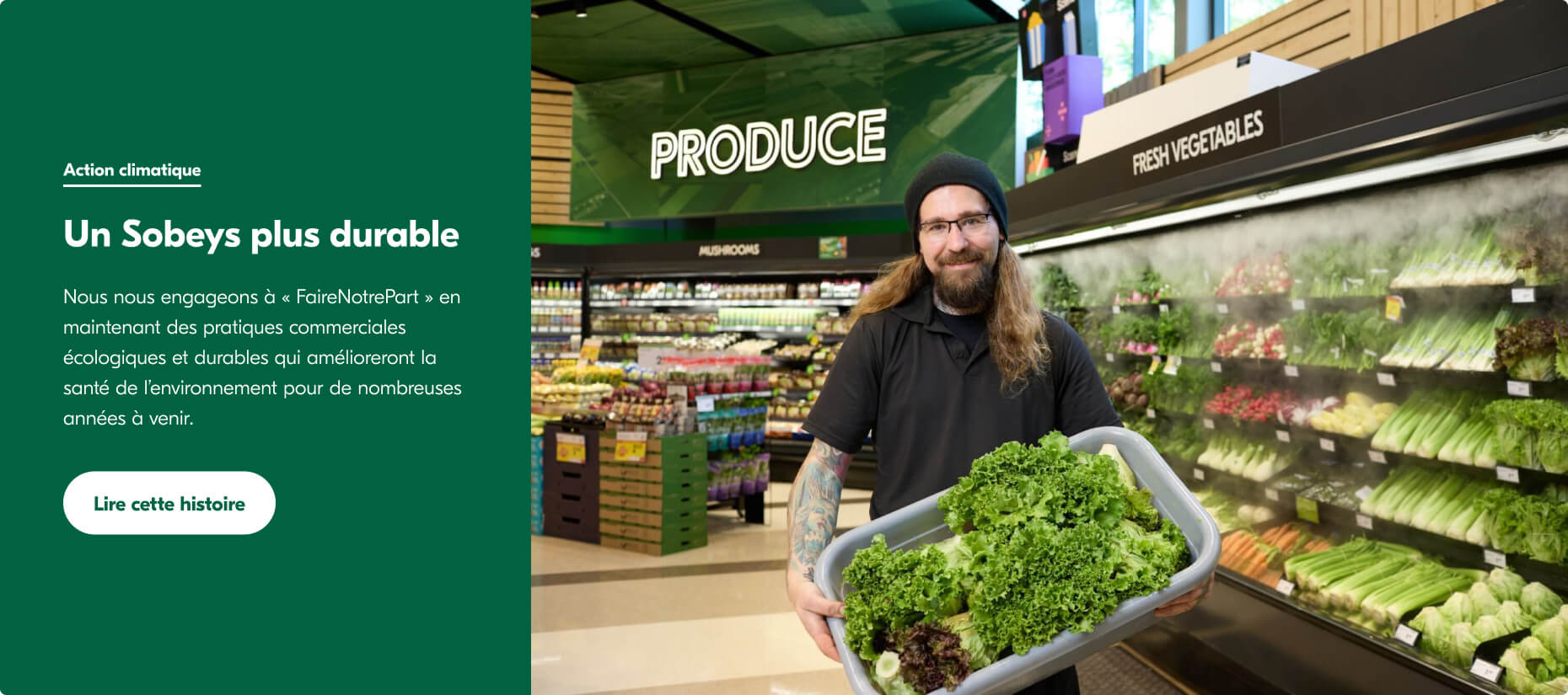 Cette image montre un homme portant une casquette et un t-shirt noirs. Il travaille dans un magasin de légumes chez Sobeys et se tient debout avec un panier rempli de légumes verts devant un présentoir.